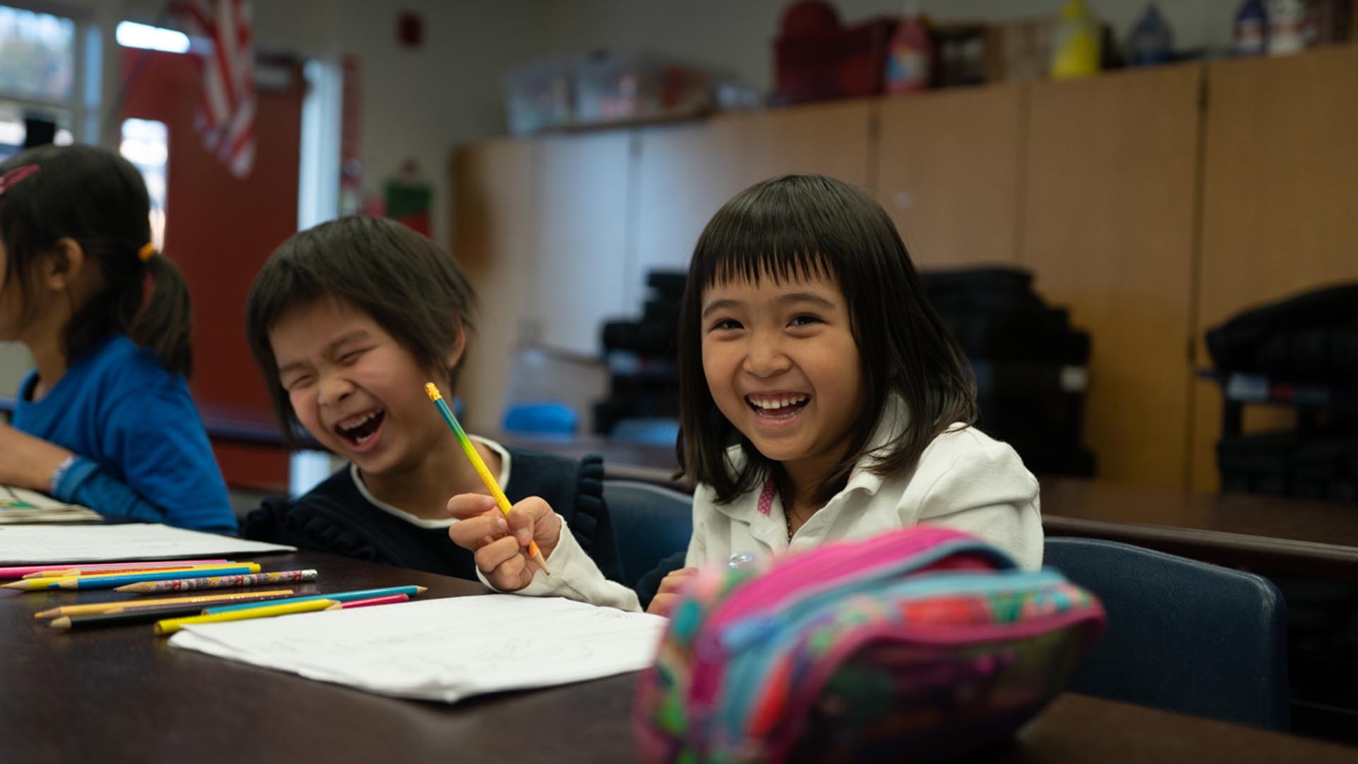 Girl students laughing together during dual language class